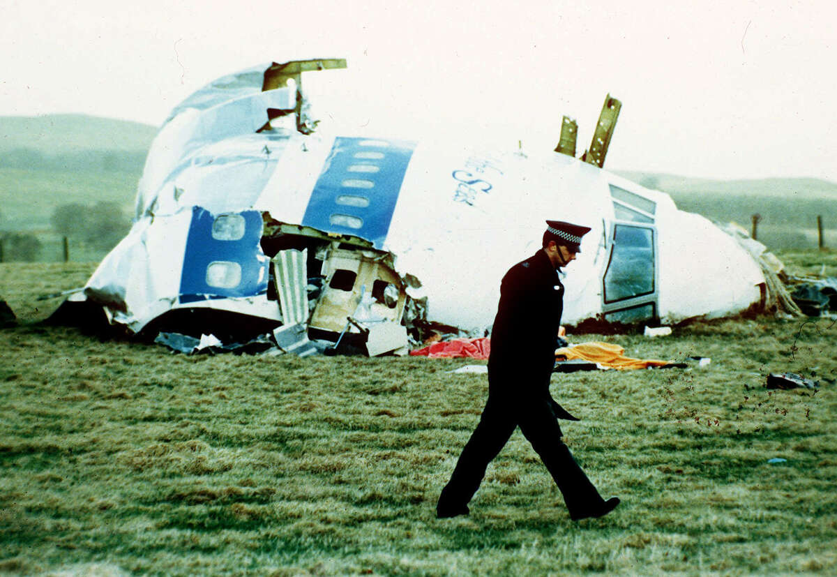 FILE - In this Wednesday, Dec. 21, 1988 file photo, a police officer walks by the nose of Pan Am flight 103 in a field near the town of Lockerbie, Scotland where it lay after a bomb aboard exploded, killing a total of 270 people. Scottish prosecutors said Thursday, Oct. 15, 2015 they have identified two Libyans as suspects in the 1988 bombing of a passenger jet over the town of Lockerbie, and want to interview them in Tripoli. Scotland?’s Crown office said that Lord Advocate Frank Mulholland and U.S. Attorney General Loretta Lynch had agreed ?“that there is a proper basis in law in Scotland and the United States to entitle Scottish and U.S. investigators to treat two Libyans as suspects in the continuing investigation into the bombing of flight Pan Am 103.?” The unnamed Libyans are suspected of involvement with Abdel Baset al-Megrahi, the only person convicted in the attack. (AP Photo/Martin Cleaver, File) ORG XMIT: LON817