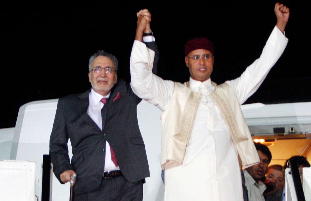FILE - In this Thursday, Aug. 20, 2009 file photo, Libyan Abdel Baset al-Megrahi, who was found guilty of the 1988 Lockerbie bombing, left, and son of the Libyan leader Seif al-Islam Gadhafi, right, gesture on his arrival at an airport in Tripoli, Libya. Scottish prosecutors said Thursday, Oct. 15, 2015 they have identified two Libyans as suspects in the 1988 bombing of a passenger jet over the town of Lockerbie, and want to interview them in Tripoli. Scotland?’s Crown office said that Lord Advocate Frank Mulholland and U.S. Attorney General Loretta Lynch had agreed ?“that there is a proper basis in law in Scotland and the United States to entitle Scottish and U.S. investigators to treat two Libyans as suspects in the continuing investigation into the bombing of flight Pan Am 103.?” The unnamed Libyans are suspected of involvement with Abdel Baset al-Megrahi, the only person convicted in the attack. (AP Photo) ORG XMIT: LON818