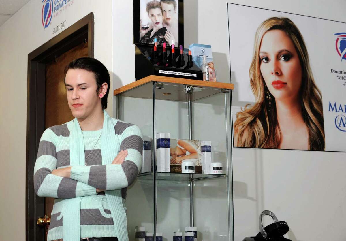 Gio Falciano is interviewed at his business Gio Expressions on Wednesday, Oct. 14, 2015 in Altamont, N.Y. Falciano is the brother of Jacquelyn Porreca, the master barber killed Aug. 21 at the Recycled Salon in Colonie. Her photo is seen in a poster to the right. (Lori Van Buren / Times Union)