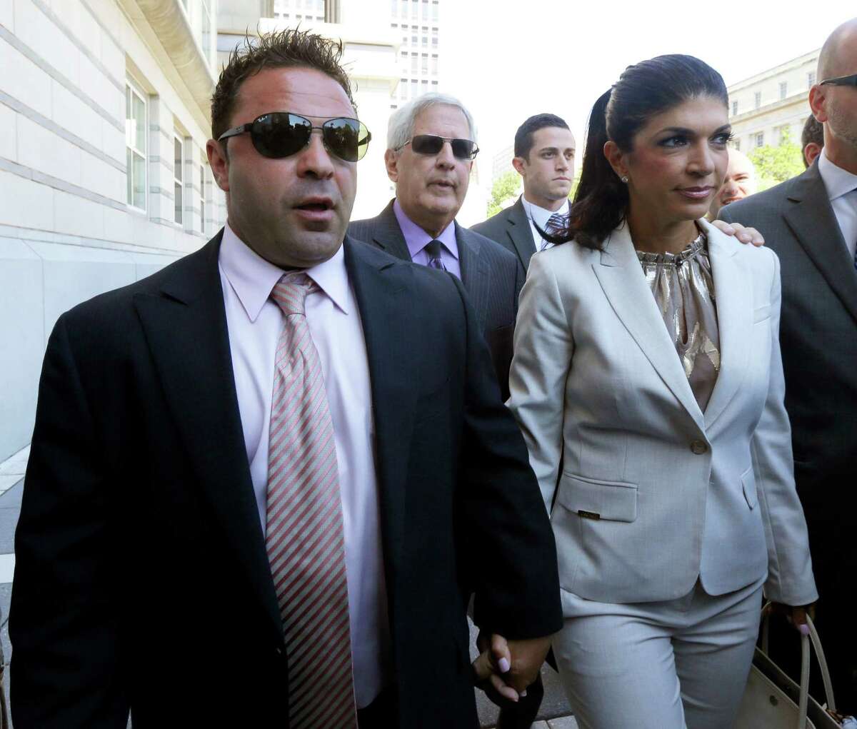 FILE - In this July 30, 2013 file photo, "The Real Housewives of New Jersey" stars Giuseppe "Joe" Giudice, 43, left, and his wife, Teresa Giudice, 41, of Montville Township, N.J., walk out of Martin Luther King, Jr. Courthouse after an appearance in Newark, N.J. Federal prosecutors cited the Giudice?’s ?“Real Housewives?” income in court filings and accuse the couple of hiding assets in a bankruptcy case filed after the show?’s first season. Both have pleaded not guilty to a host of financial fraud charges dating back to 2001. (AP Photo/Julio Cortez, File)