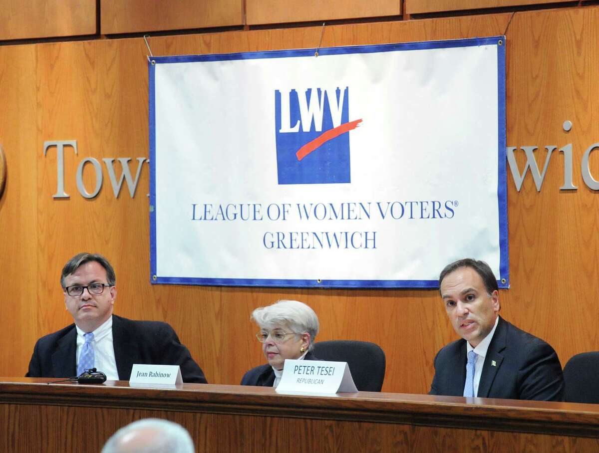 At left, Democratic candidate for First Selectman Frank Farricker listens as incumbent First Selectman Peter Tesei, the Republican candidate for the office, at right, speaks during the League of Women Voters of Greenwich Selectmen debate at Greenwich Town Hall, Greenwich, Conn., Thursday night, Oct. 15, 2015. At center is moderator Jean