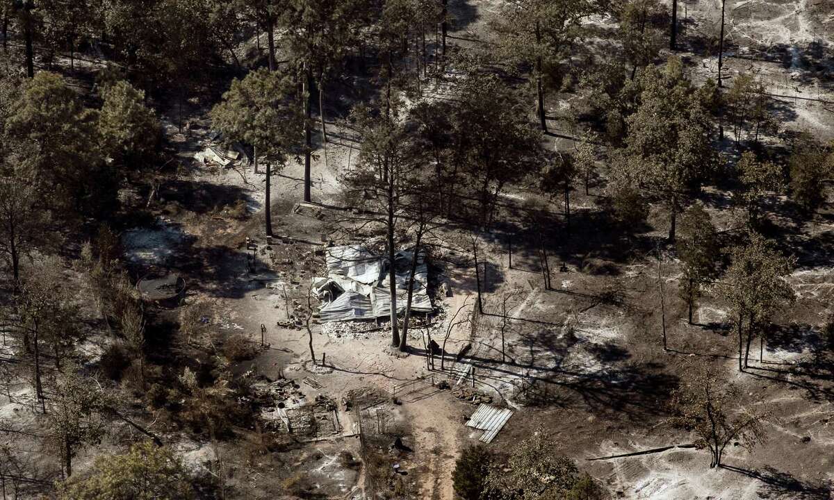 Ahome destroyed by the Hidden Pines Fire is surrounded by burned landscape near Smithville. A preliminary investigation indicates a farming accident sparked the wildfire, which was about 50 percent contained late Friday.