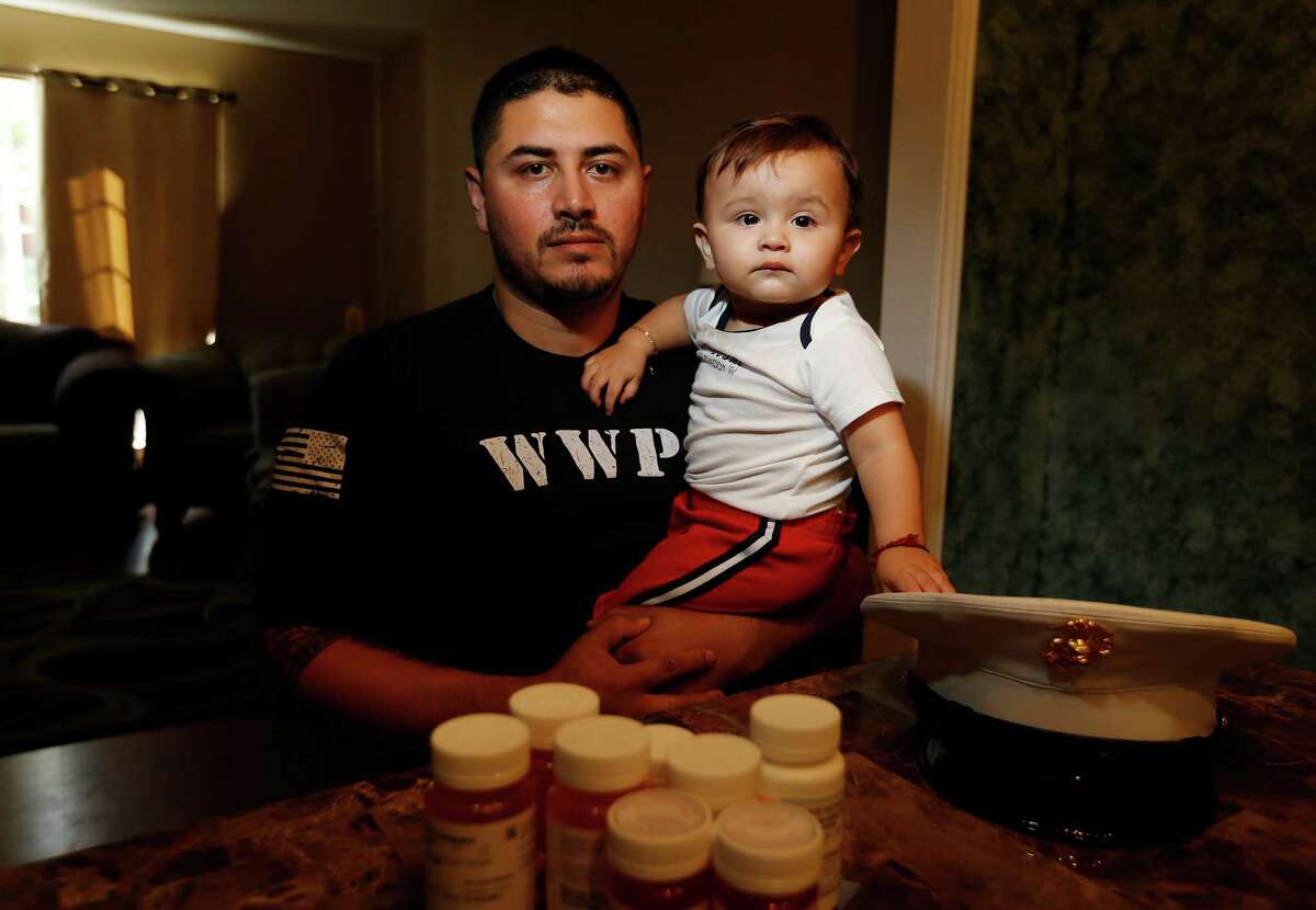 Iraq and Afghanistan Marine veteran Cesar Gutierrez - holding his 13-month old son Cesar - has struggled to receive timely mental health care from the Veteran Administration system. He was medically retired from the Marines with brain injury and PTSD and relies on constant visits to the VA hospital to maintain his health. But delays as long as three months to a year have frustrated him as he tries to live a life of normalcy outside the active military. (Kin Man Hui/San Antonio Express-News)