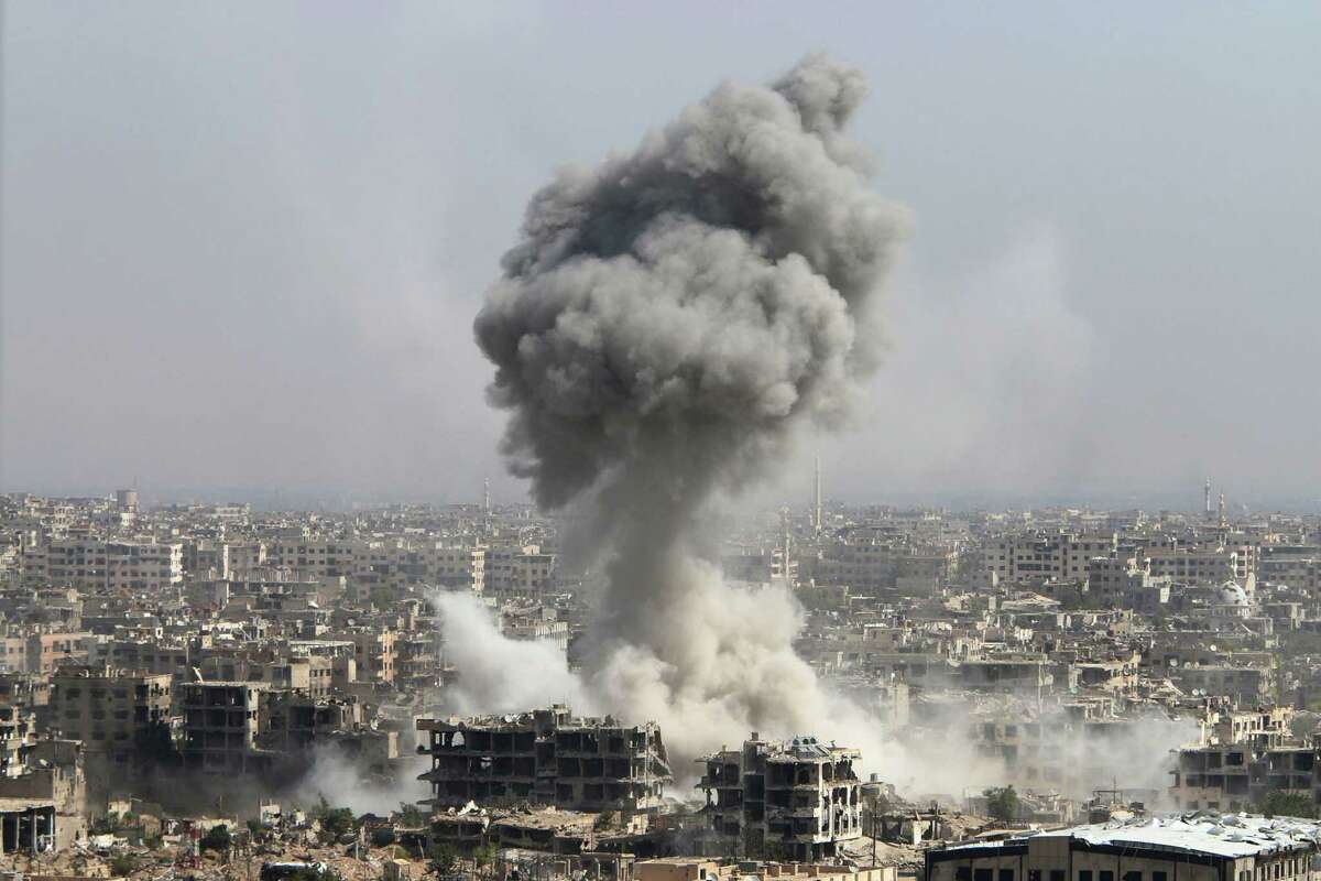 In this photo taken on Wednesday, Oct. 14, 2015, smoke rises after shelling by the Syrian army in Jobar, Damascus, Syria. Backed by Russian airstrikes, the Syrian army has launched an offensive in central and northwestern regions. (Alexander Kots/Komsomolskaya Pravda via AP) RUSSIA OUT