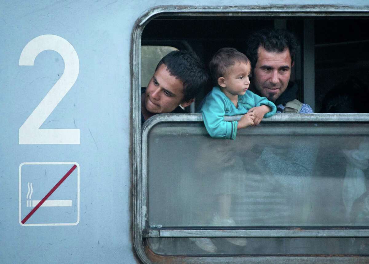 Migrants looks from a train window as they arrive in Cakovec, near the Croatian-Slovenian border, Saturday, Oct. 17, 2015. Hungary shut down its border with Croatia to the free flow of migrants, prompting Croatia to redirect thousands of people toward its border with Slovenia. (AP Photo/Darko Bandic)
