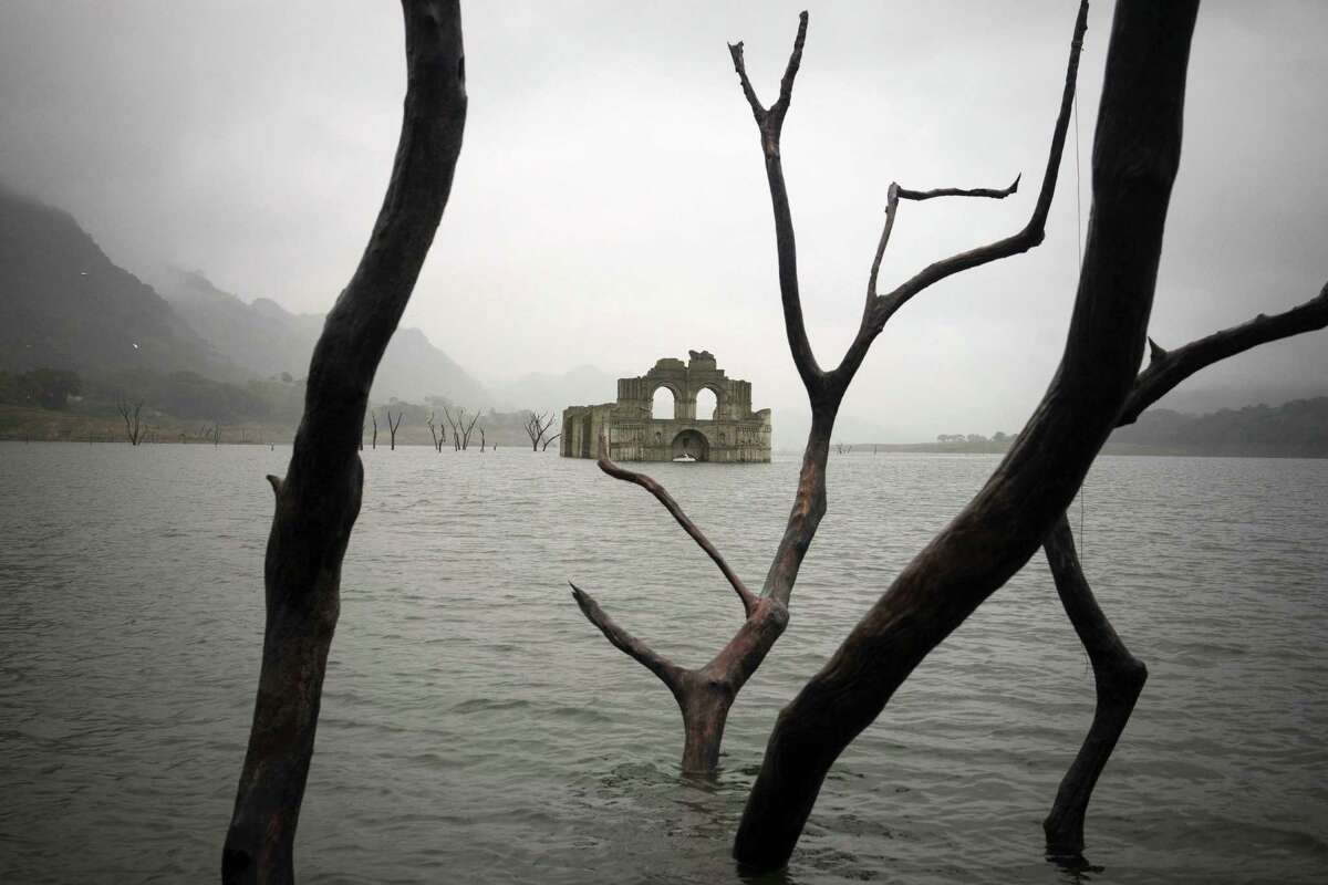 The remains of a mid-16th century church known as the Temple of Santiago, as well as the Temple of Quechula, is visible from the surface of the Grijalva River, which feeds the Nezahualcoyotl reservoir, due to the lack of rain near the town of Nueva Quechula, in Chiapas state, Mexico, Friday, Oct. 16, 2015. The temple, built by Dominican friars in the region inhabited by the Zoque people, was submerged in 1966 when the Nezahualcoyotl dam was built. (AP Photo/David von Blohn)