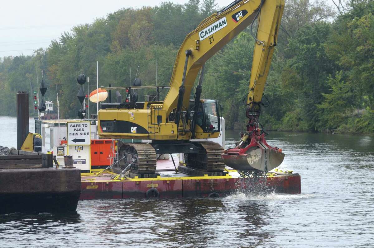 A operator in a backhoe drops material to cap the bottom the Hudson River as seen during a boat tour along the Champlain Canal and the Hudson River to see the PCB dredging process taking place on Thursday, Sept. 22, 2011 near Fort Edward. A cap is placed in a area that after two dredging some PCB material still remains. The tour was open to members of the media, members of the Community Advisory Group for the Hudson River PCBs Superfund Site and other interested parties. The State's Canal Corp provided the boat and the EPA gave the tour. (Paul Buckowski / Times Union)