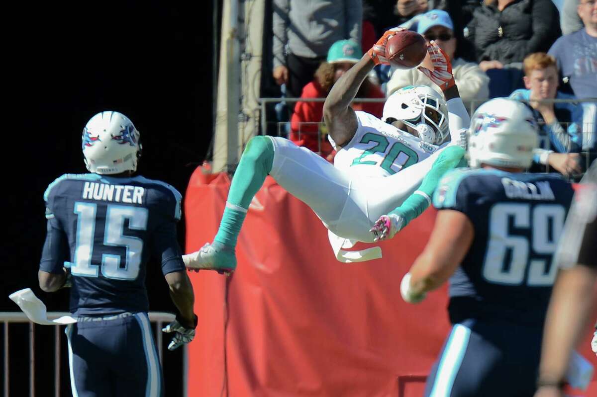 Dolphins safety Reshad Jones punctuates his interception return for a touchdown with a bit of acrobatics against the Titans.