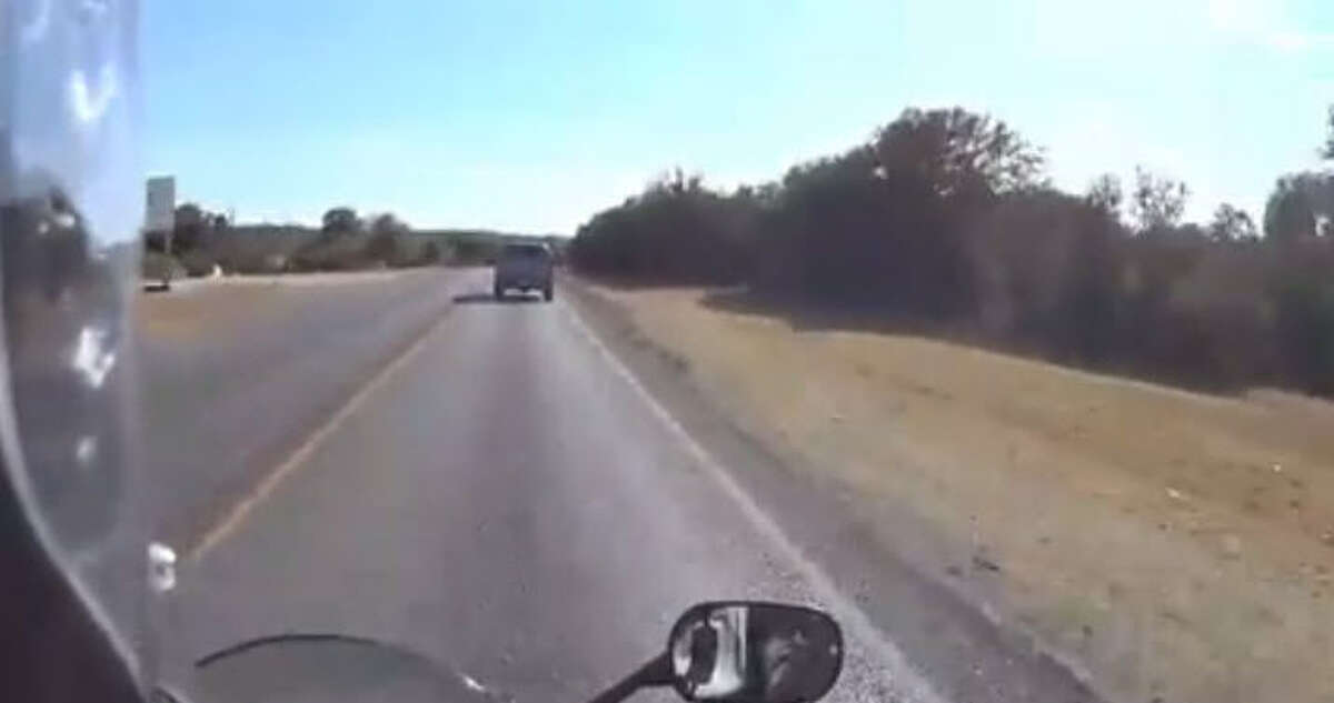 Video taken from a man riding a motorcycle in Texas appears to show a driver in a sedan swerving to hit riders on another motorcycle. (Still frames via Facebook video by Eric Sanders)