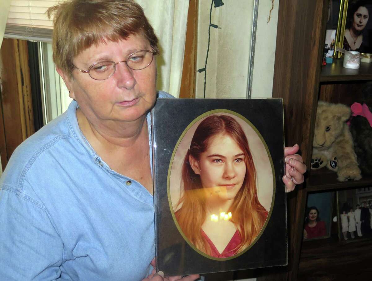 In this Oct. 16, 2015 photo, Carolyn Tousignant hold a photo of her daughter Carrie Ann Jopek, at her home in Milwaukee, Wis. Authorities have charged Jose Ferreira with murder after he called a Milwaukee TV newsroom and discussed details of a cold case involving Jopek, a seventh-grade girl whose body was found more than 30 years ago. (AP Photo/Greg Moore)