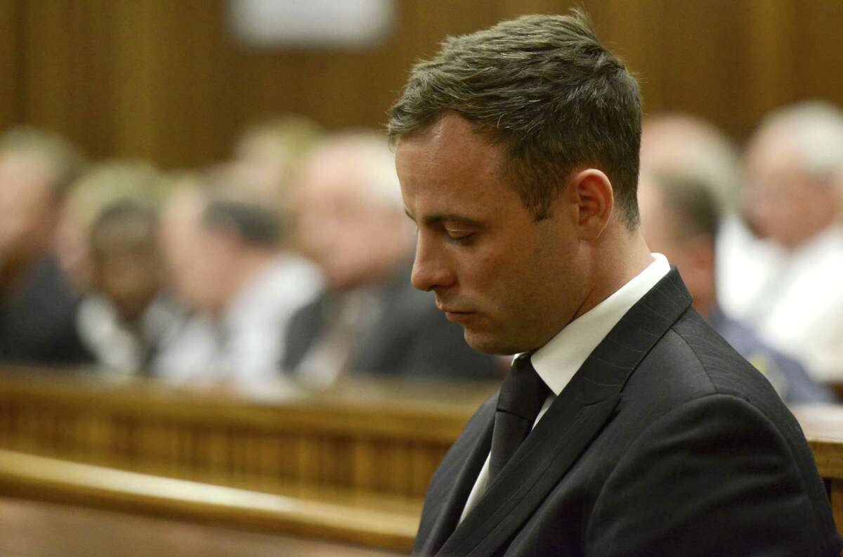 FILE - In this Tuesday, Oct. 21, 2014 file photo, Oscar Pistorius sits in court in Pretoria, South Africa, after judge Thokozile Masipais sentenced him to five years imprisonment for culpable homicide. A South African official says Oscar Pistorius has been released from prison and placed under house arrest. Manelisi Wolela, a spokesman for South Africa's correctional services department, said the double-amputee Olympic runner who fatally shot his girlfriend on Valentine's Day 2013 was put under "correctional supervision" late on Monday, Oct. 19, 2015. (Herman Verwey/Pool photo via AP, file)