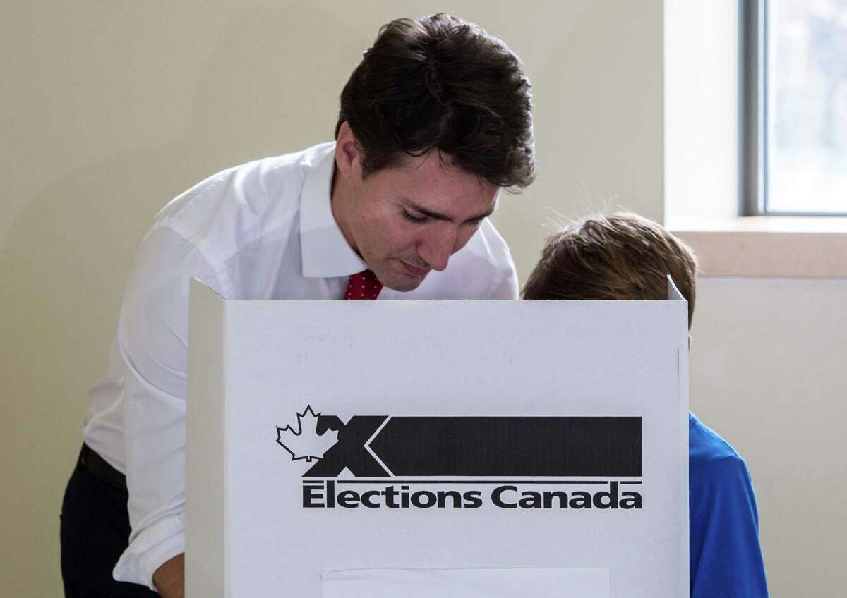 Liberal leader Justin Trudeau casts his vote, accompanied by his son Xavier, Monday, Oct. 19, 2015 in Montreal. Canadians voted Monday to decide whether to extend Conservative Prime Minister Stephen Harper's near-decade in power or return Canada to its more liberal roots. (Paul Chiasson/The Canadian Press via AP) MANDATORY CREDIT