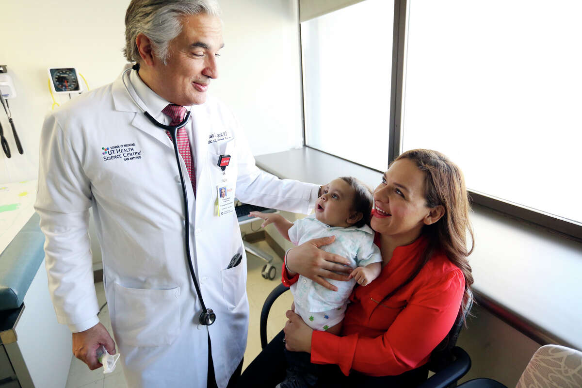 Dr. Francisco Cigarroa, surgical director of the pediatric transplant program at University Hospital, and professor of surgery at the University of Texas Health Science Center, (left) talks with Yamely Acosta and her son Hector Acosta III, 9-months, Monday Oct. 19, 2015 at the hospital. Dr. Cigarroa and colleagues performed a pediatric liver transplant on Hector Aug. 26, 2015.