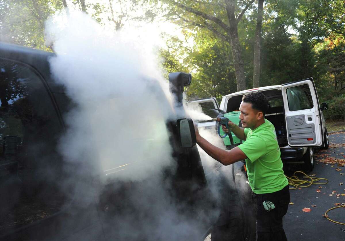 Birdie's Auto Spa employee Adrass Flores performs a steam car wash at a client's house in Greenwich, Conn. Tuesday, Oct. 20, 2015. Birdie's uses an eco-friendly soapless steam cleaning system to wash car interiors and exteriors, as well as items like car seats and strollers. The company hauls its equipment in a van so they are able to make house calls and wash multiple cars during the day.
