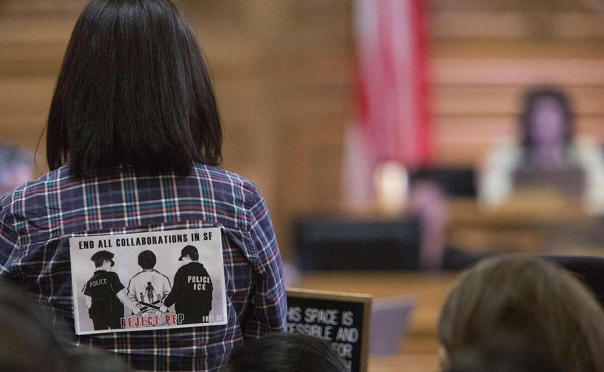 Yadira Sanchez, whose father was mistakenly deported, stands while her story is told in front of the Board of Supervisors at City Hall on Tuesday, Oct. 20, 2015 in San Francisco, Calif.