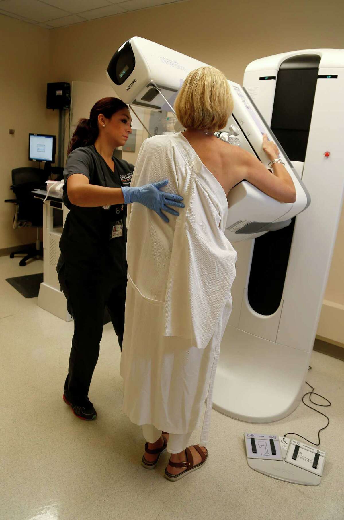 A cancer survivor gets a routine mammogram screening by tech Joanna Esquivel in Houston. 