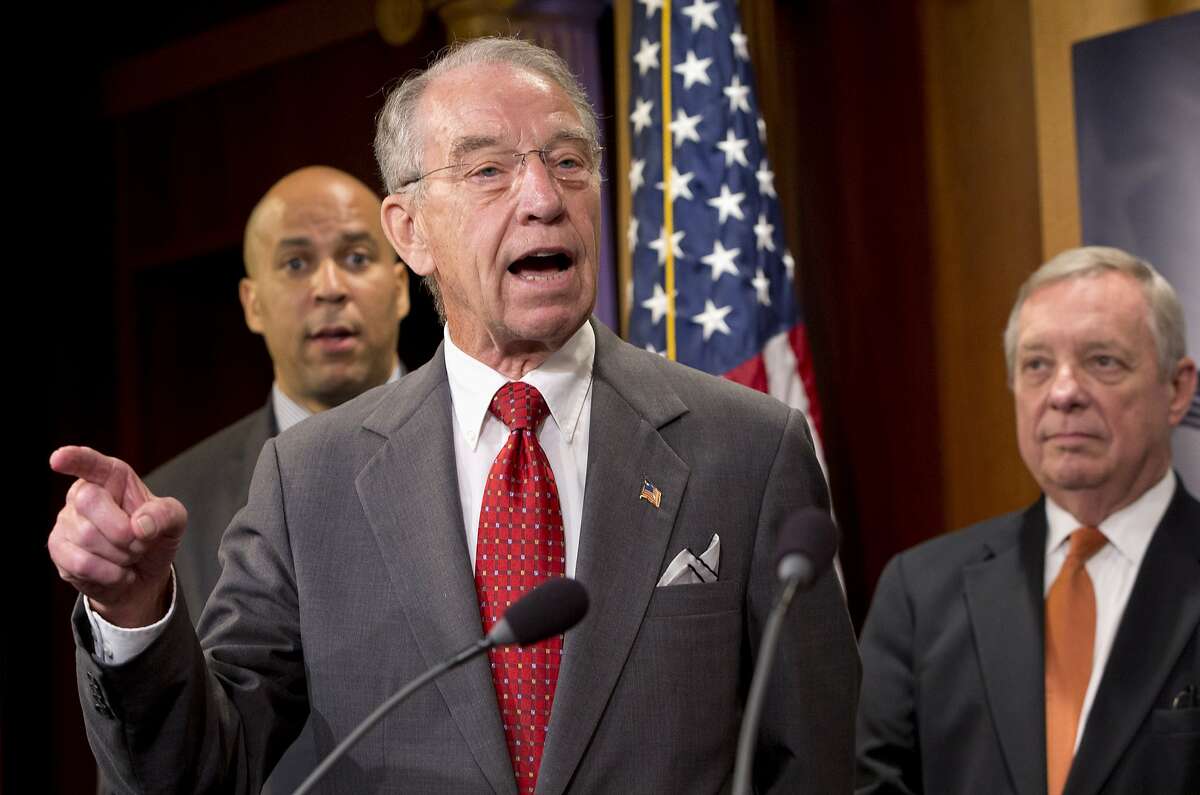 Senate Judiciary Committee Chairman Sen. Charles Grassley, R-Iowa, center, flanked by Sen. Cory Booker, D-N.J., left, and Senate Minority Whip Richard Durbin of Ill., speaks about criminal justice reform, Thursday, Oct. 1, 2015, during a news conference on Capitol Hill in Washington. A long-awaited bipartisan proposal to cut mandatory prison sentences for nonviolent offenders and promote more early release from federal prisons is scheduled to be disclosed Thursday by an influential group of senators who hope to build on backing from conservatives, progressives and the White House. (AP Photo/Jacquelyn Martin)