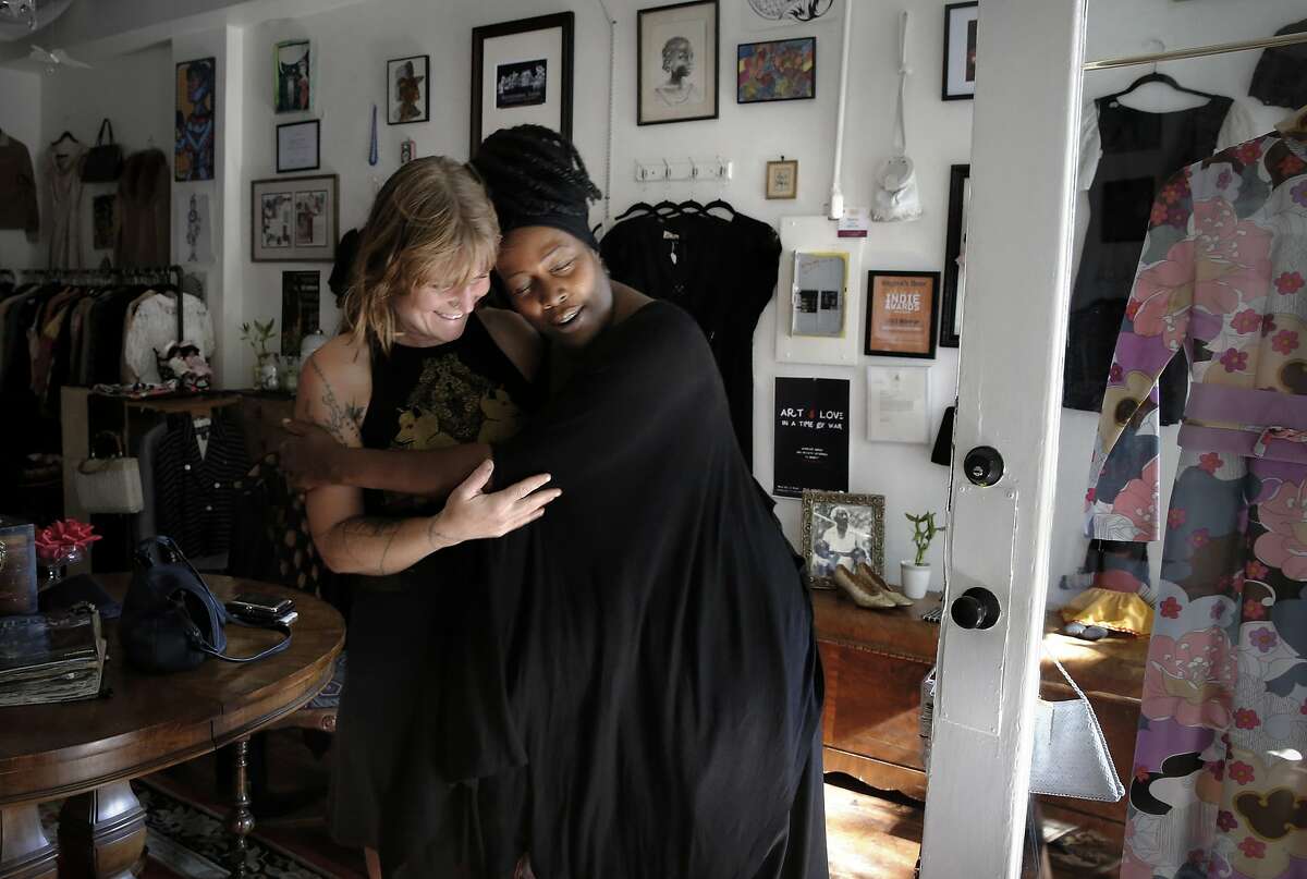 Trinity Cross, (left) owner of the field day & friend handcrafted boutique which is nearby gets a hug from Regina Evans during a visit to see her friend. Regina's Door is a consignment shop started by Regina Evans, a survivor of sex trafficking, who is celebrating her one year anniversary in Oakland, Calif., at the shop she uses to raise money and awareness for survivors of human trafficking and employs women who survived the sex trade. Regina is seen in her shop on Fri. October 16, 2015.
