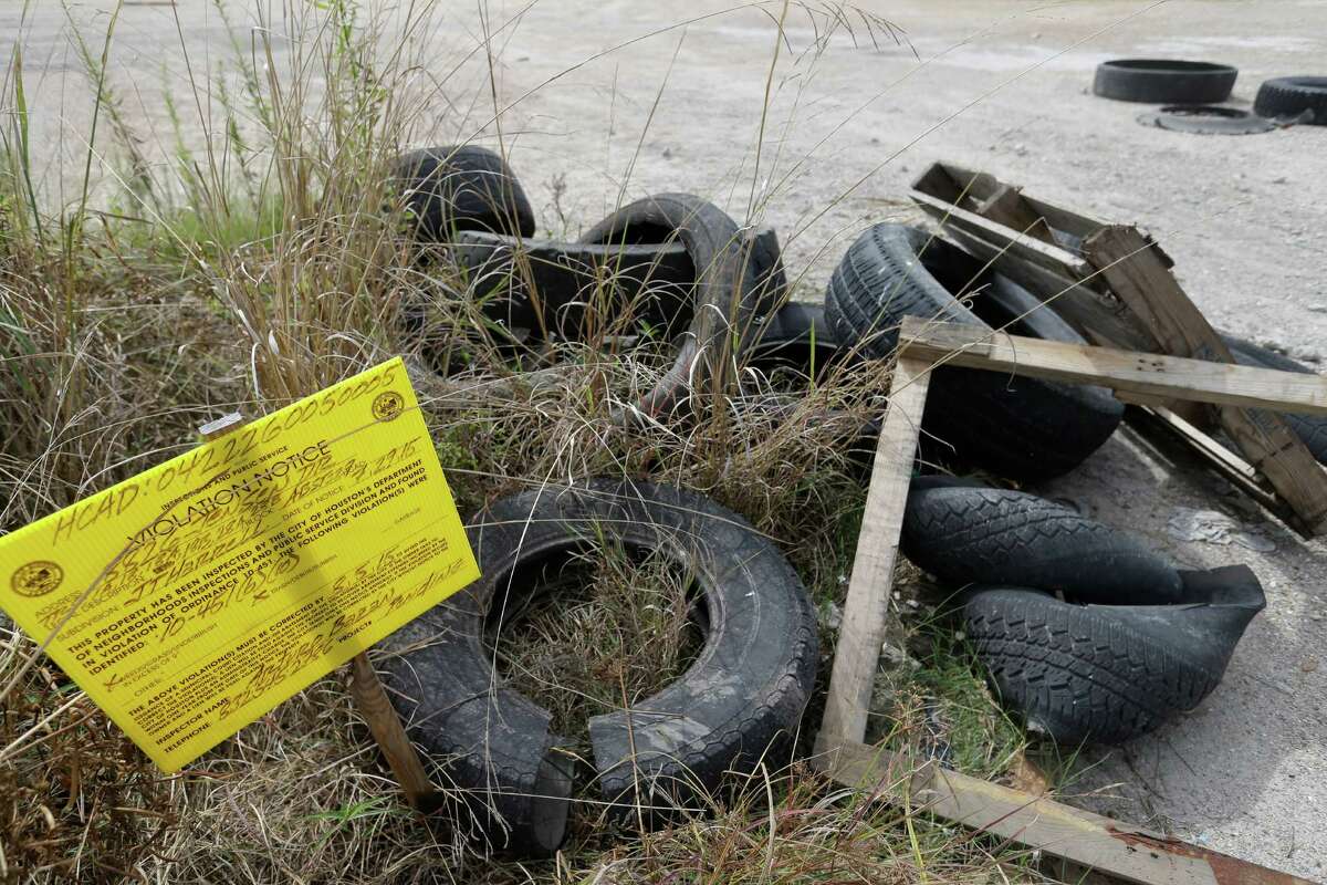 A City of Houston violation notice is posted among tires and debris along Laura Koppe Rd. at the intersection of Jensen St. Wednesday, Oct. 21, 2015, in Houston.