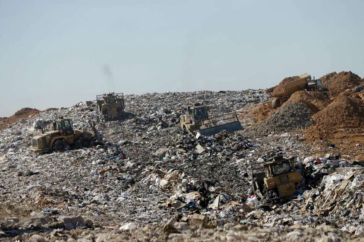 Machines work to compact the trash at the landfill as trucks bring dirt that will be used to cover over the compacted trash at the Waste Management Atascocita Recycling and Disposal Facility, 3623 Wilson Road, is shown Thursday, Oct. 15, 2015, in Humble. ( Melissa Phillip / Houston Chronicle )