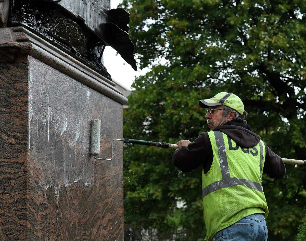 DGS worker Doug Abaire applies sodium hydroxide in an effort to remove graffiti from the face of the Vietnam War Memorial in Academy Park Thursday morning Oct. 22, 2015 in Albany, N.Y. (Skip Dickstein/Times Union)