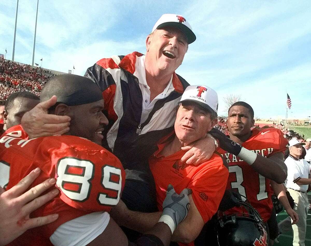 Texas Tech head coach Spike Dykes is lifted by Texas Tech alum and All-American E.J. Holub, right, and Taurus Rucker (89) after beating Oklahoma 38-28 in Lubbock on Nov. 20, 1999. Dykes announced his retirement after the game.