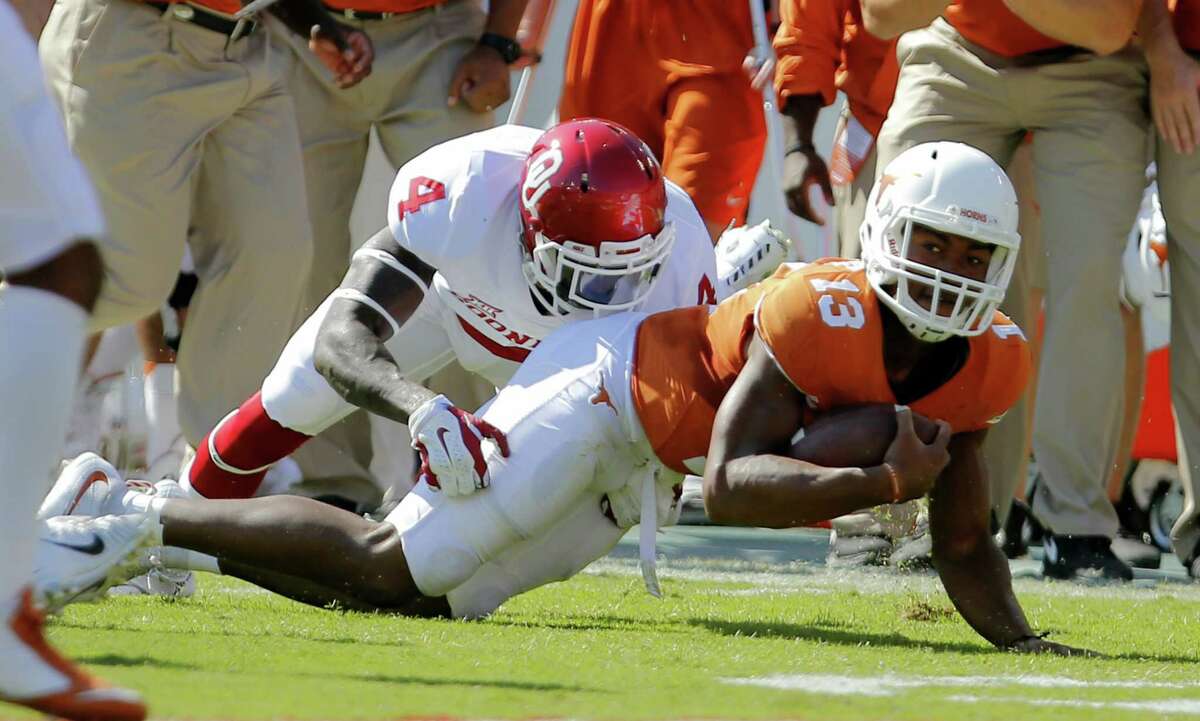Oklahoma safety Hatari Byrd (left) tackles Texas quarterback Jerrod Heard during the first half at the Cotton Bowl in Dallas on Oct. 10, 2015. Texas won, 24-17.