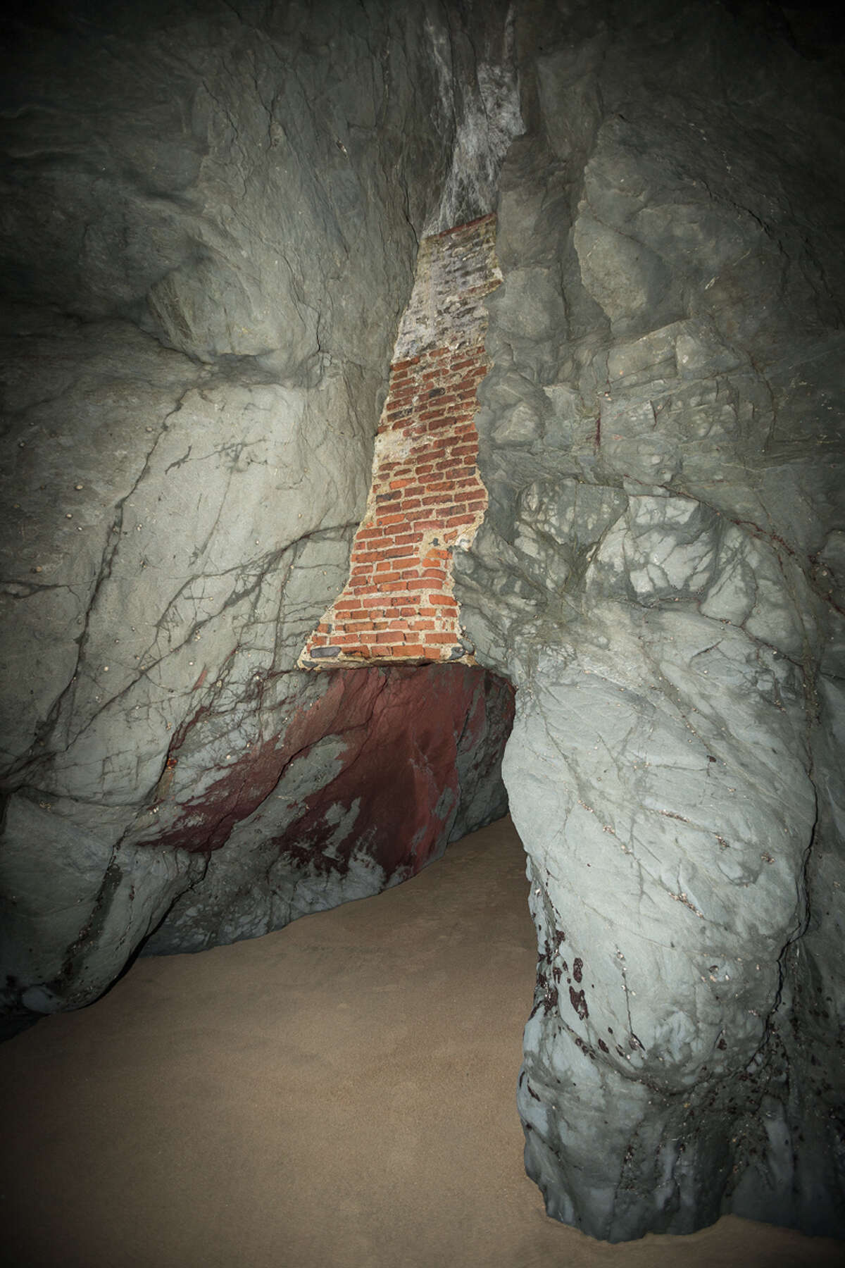 The only access point to the 250-foot-long mine tunnel is a sea cave with remnants of brick and iron infrastructure.