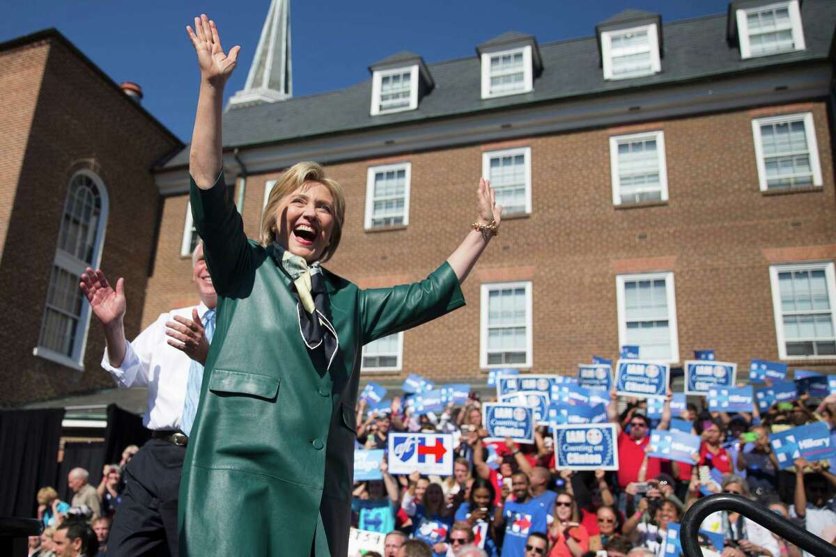 Democratic presidential candidate, former Secretary of State Hillary Rodham Clinton, accompanied by Virginia Gov. Terry McAuliffe, smiles and waves as she arrive for a campaign rally, Friday, Oct. 23, 2015, in Alexandria, Va. (AP Photo/Evan Vucci)