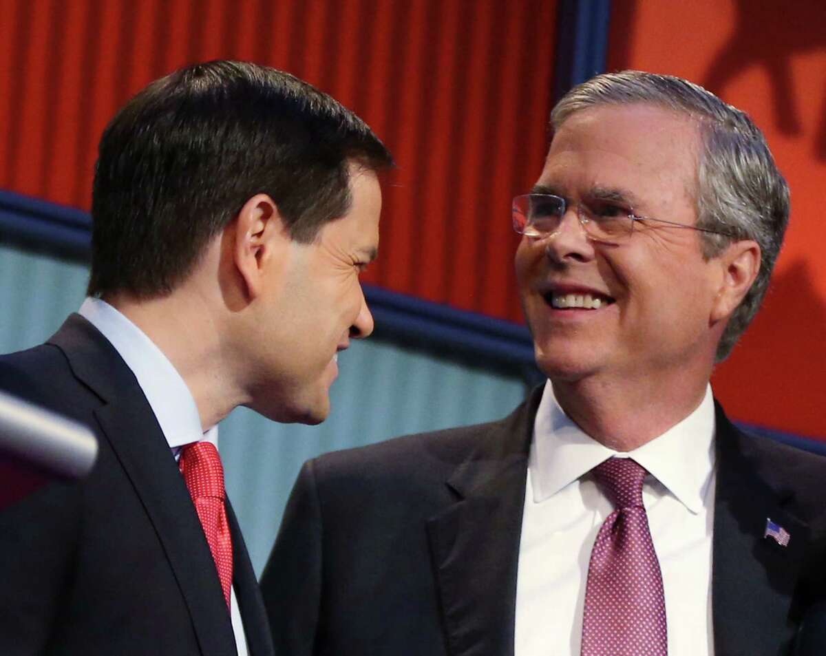 GOP presidential candidate Jeb Bush (right) on Friday slashed his campaign payroll by 40 percent.