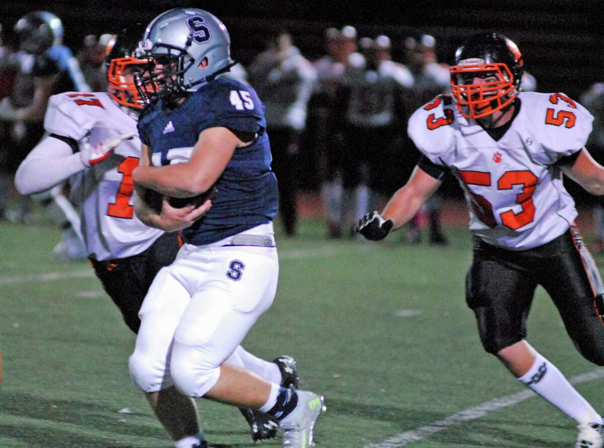 Staples' Jon Maragos, left, runs with the ball during a football game against Ridgefield on Friday, October 23rd, 2015 in Westport, Connecticut.