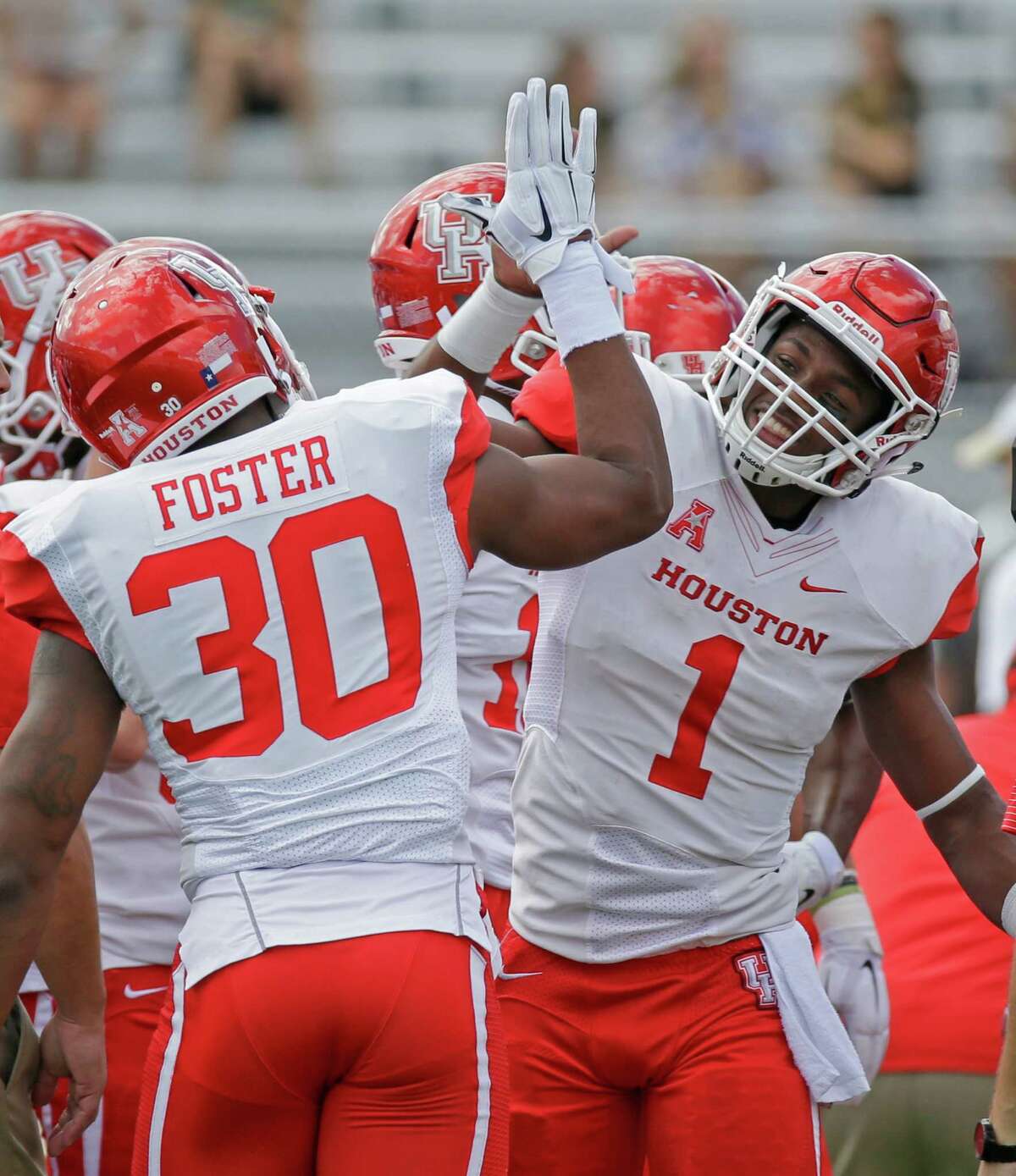 Houston quarterback Greg Ward Jr. (1) high fives teammate safety Earl Foster (30) during warm ups before an NCAA college football game against Central Florida, Saturday, Oct. 24, 2015, in Orlando, Fla. (AP Photo/John Raoux)