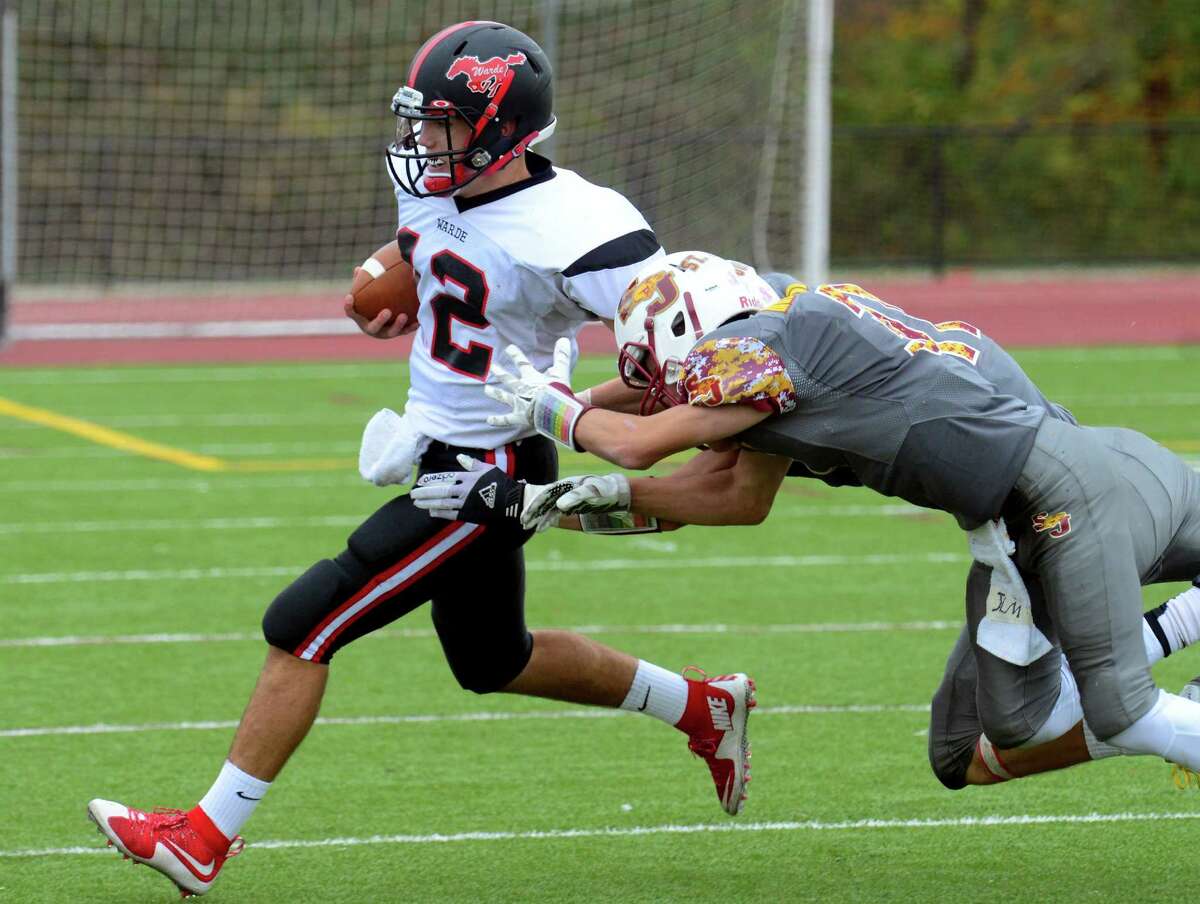Fairfield Warde QB Jack Potenza tries to shake St. Joseph's Jared Mallozzi and Cameron Ryan during high school football action in Trumbull, Conn. on Saturday October 24, 2015.