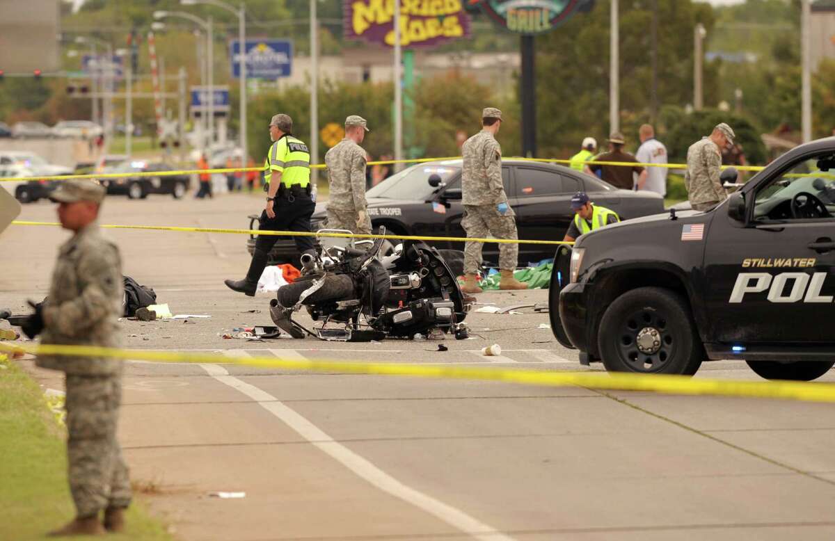 A damaged police motorcycle rests in the intersection after a vehicle crashed into a crowd of spectators during the Oklahoma State University homecoming parade, causing multiple injuries, on Saturday, Oct. 24, 2015 in Stillwater, Oka.(AP Photo/Brody Schmidt)