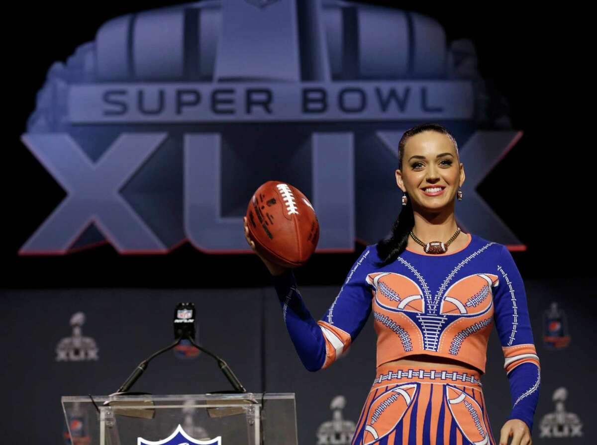 Katy Perry poses with a football at a halftime news conference for NFL Super Bowl XLIX football game Thursday, Jan. 29, 2015, in Phoenix. (AP Photo/Morry Gash) ORG XMIT: NFL124