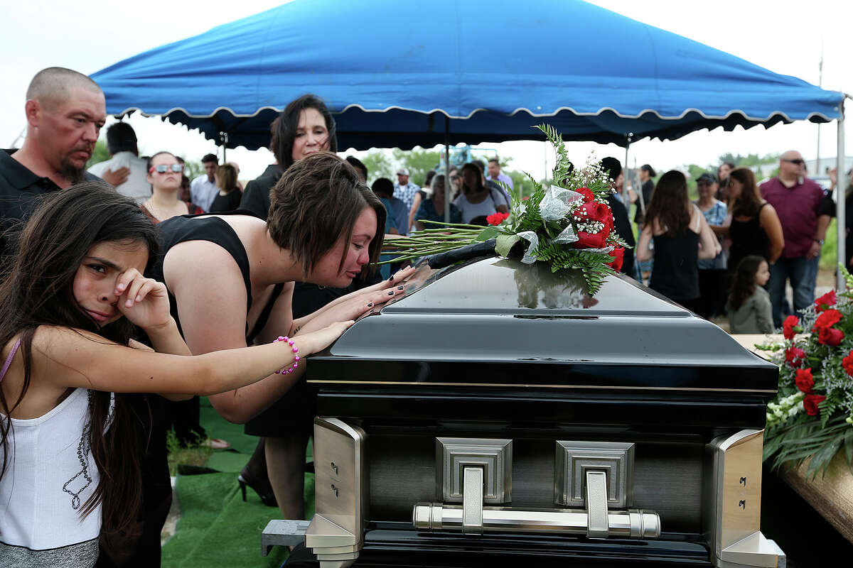 Danielle Daniel Lerma kisses her husband's casket during a burial ceremony in Freer, Texas, Thursday, May 7, 2015. Nestor Lerma, Jr, was one of the oil rig workers that was featured in a series of stories on San Antonio wildcatter Harvey Howell in 2013. Lerma died as a result of an accident on a drilling site in Duval County on May 1. Next to her is Lerma's niece, Nadia Lerma, 9.