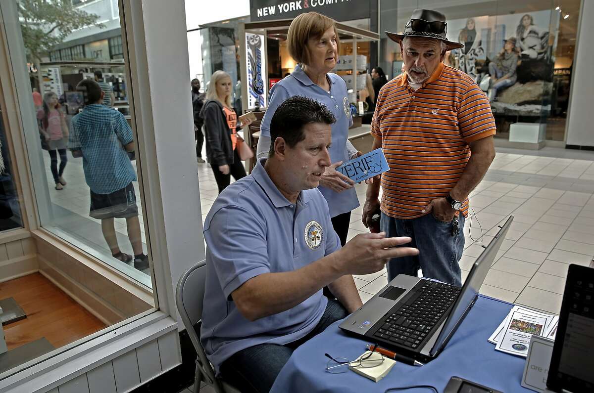 Mike Walker and Lois Ranftle representatives with the Medical Board of California meet with Jack Gonzales, (right) of Sacramento during an outreach at the Arden Mall in Sacramento, Calif. on Sat. October 24, 2015, showing the public how they can access information about whether or not their medical doctor is in good standing with the state, the data showed his physician was just fine.