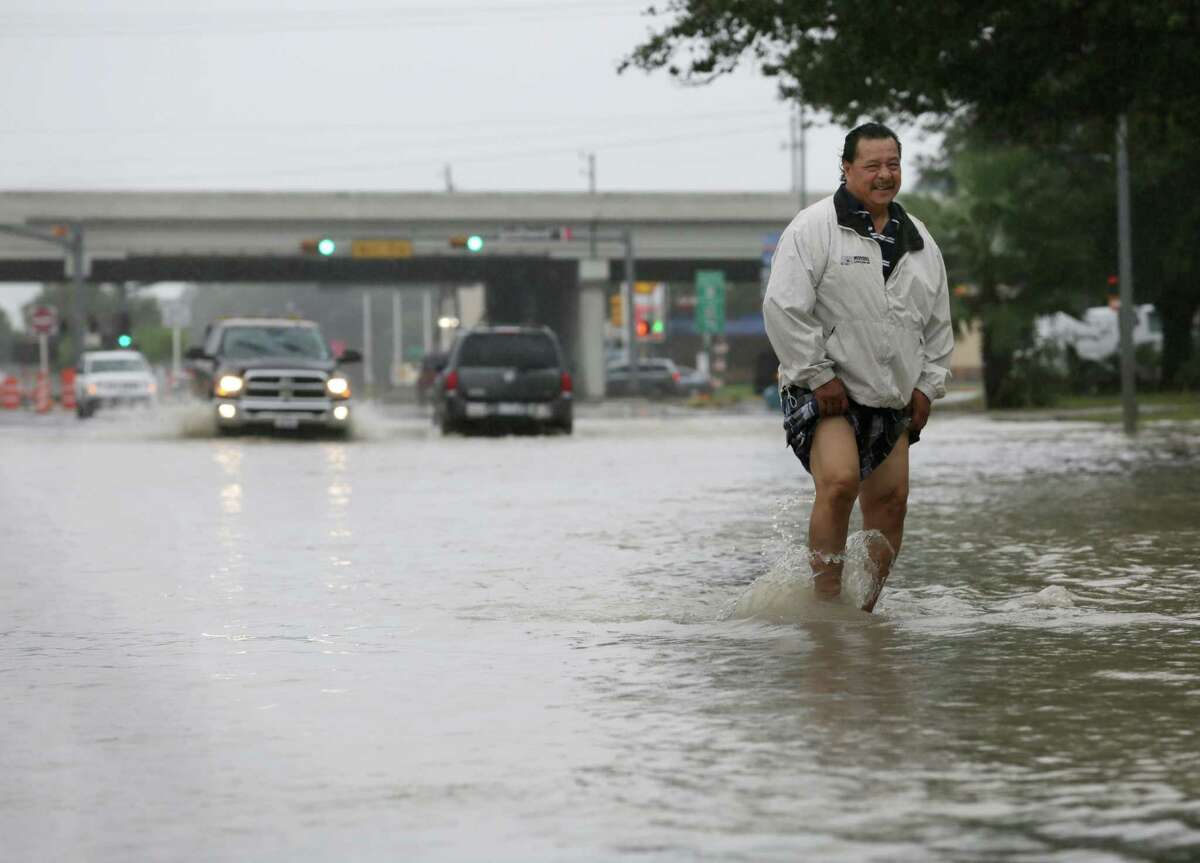 Eleazar Sanchez wades through high water on Fondren Road near the Southwest Freeway to test its depth before driving through it Sunday, Oct. 25, 2015, in Houston. Heavy rains moved into the area over night dropping four to nine inches of rain across parts of Harris County.