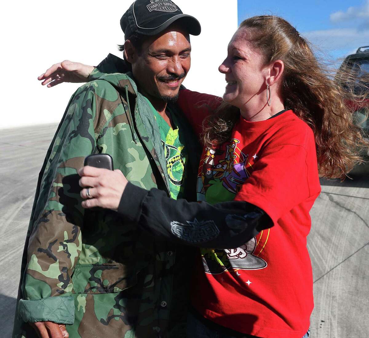 Roel Martinez, 41, gets a hug from his girlfriend, Angela Crandall, 41, after he survived falling into a drainage culvert full of storm water on Saturday, Oct. 25, 2015. Martinez showed up at a press conference held by the San Antonio Fire Department Chief Charles Hood on Sunday, Oct 25, 2015. Martinez went missing after he attempted to keep his dog, "Chico," from falling into the storm drainage near the intersection of Babcock Road and Fredericksburg in the early hours on Saturday. He was carried by the water through a tunnel and surfaced down stream. His dog also survived.