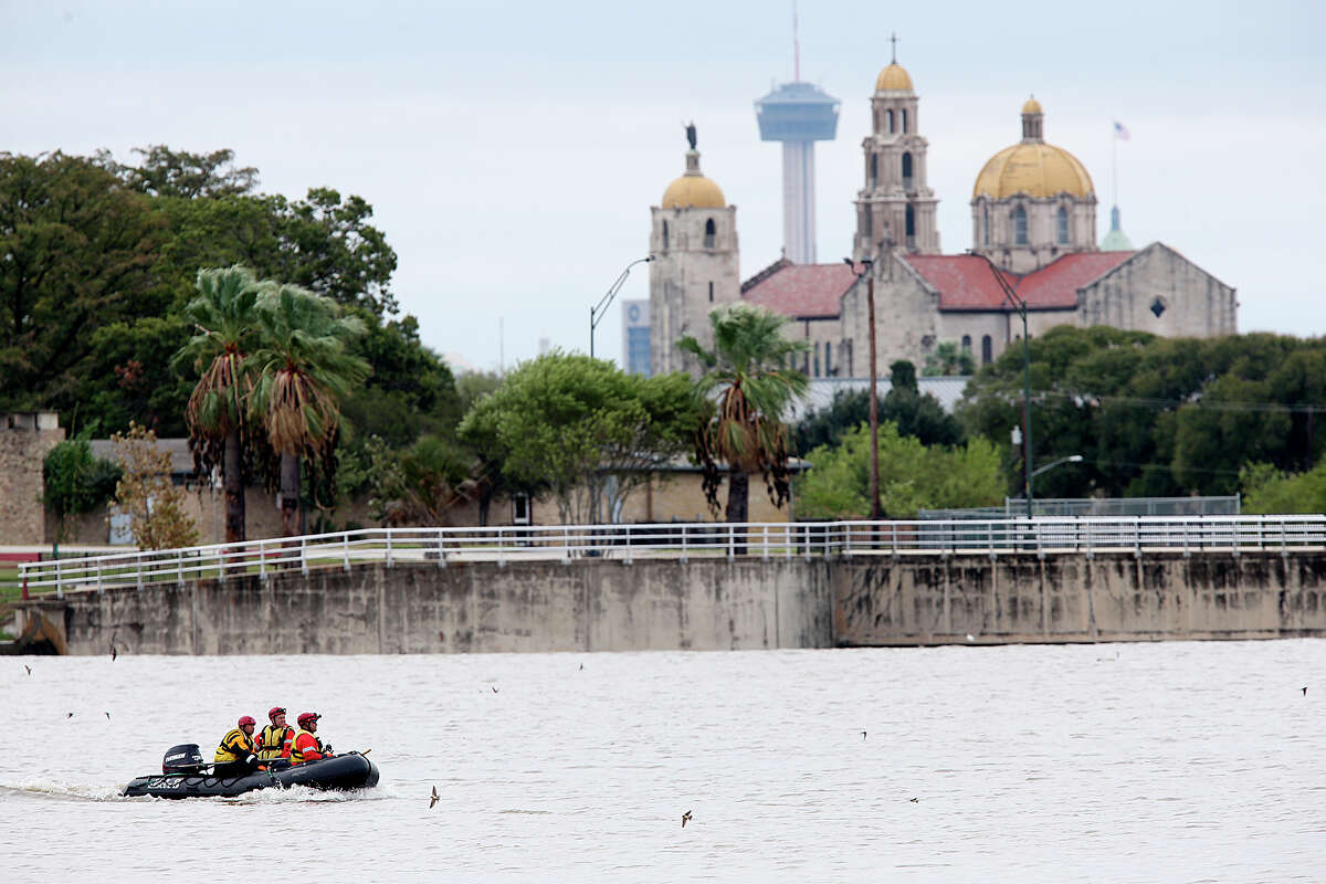 San Antonio Fire Department personnel search for a missing man at Woodlawn Lake, Sunday, Oct. 25, 2015. The man was swept away by storm waters in a drainage ditch as he went chasing after his dog early Saturday morning. Heavy rains throughout the weekend causes creeks and draining ditches to swell with water.