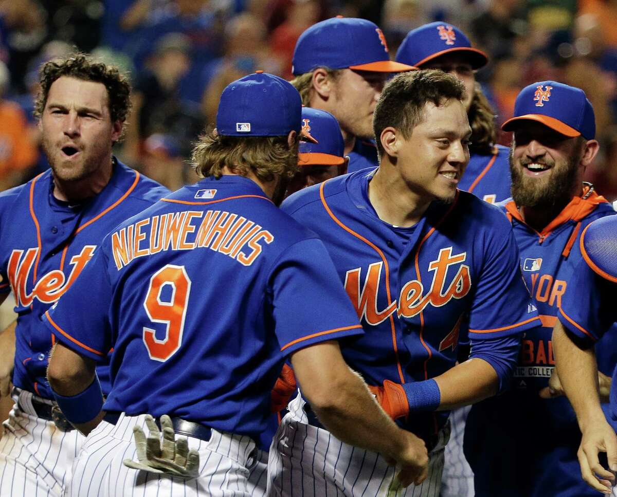 In this Friday, July 31, 2015, file photo, New York Mets' Wilmer Flores, center right, is mobbed by teammates after hitting a walk-off solo home run during the 12th inning of a baseball game to defeat the Washington Nationals 2-1, in New York, just two days after Flores thought he had been traded. The Mets' storybook ride to the World Series this season has been marked by several seminal moments. (AP Photo/Julie Jacobson, File) ORG XMIT: NYSB702