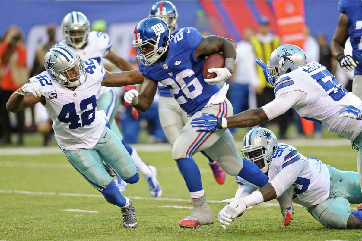 New York Giants running back Orleans Darkwa (26) breaks a tackle by Dallas Cowboys' Demarcus Lawrence (90) on his way to a touchdown during the first half of an NFL football game Sunday, Oct. 25, 2015, in East Rutherford, N.J. (AP Photo/Bill Kostroun)