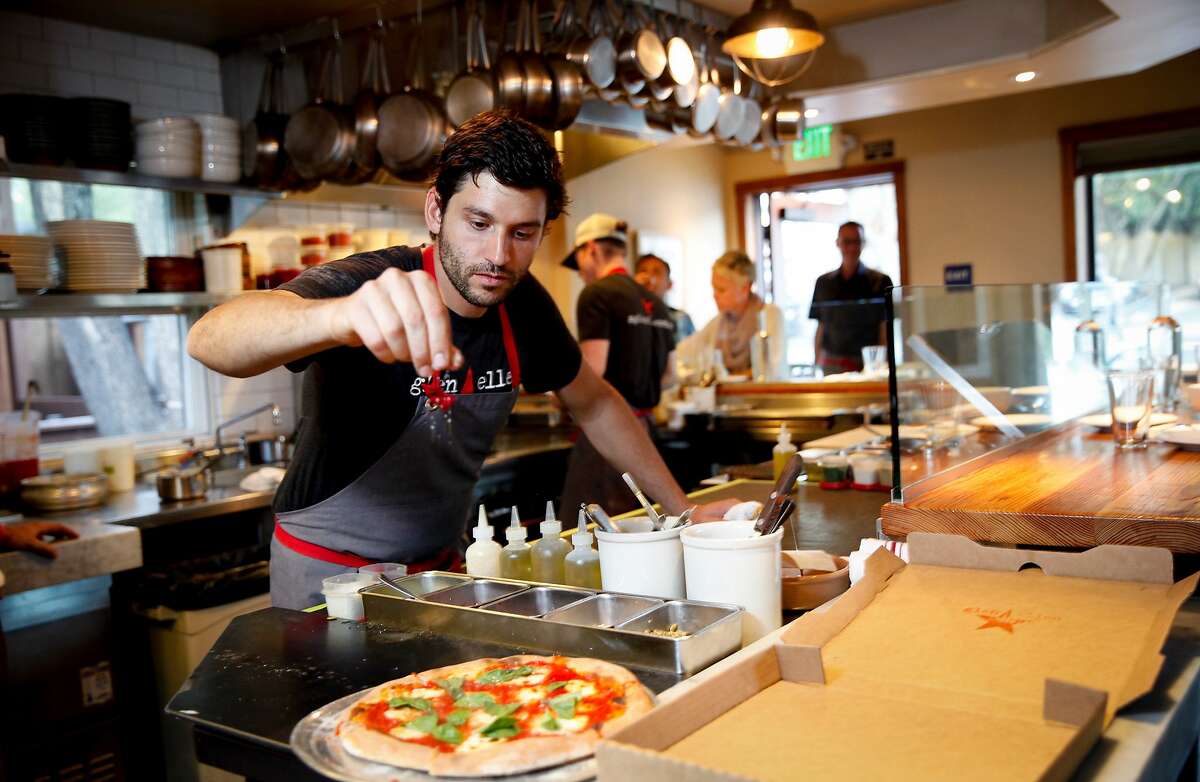 Sous chef Louis Abruzzese puts the finishing touches on a pizza from the wood oven at Glen Ellen Star in Glen Ellen, Calif., on Thursday, October 22, 2015.