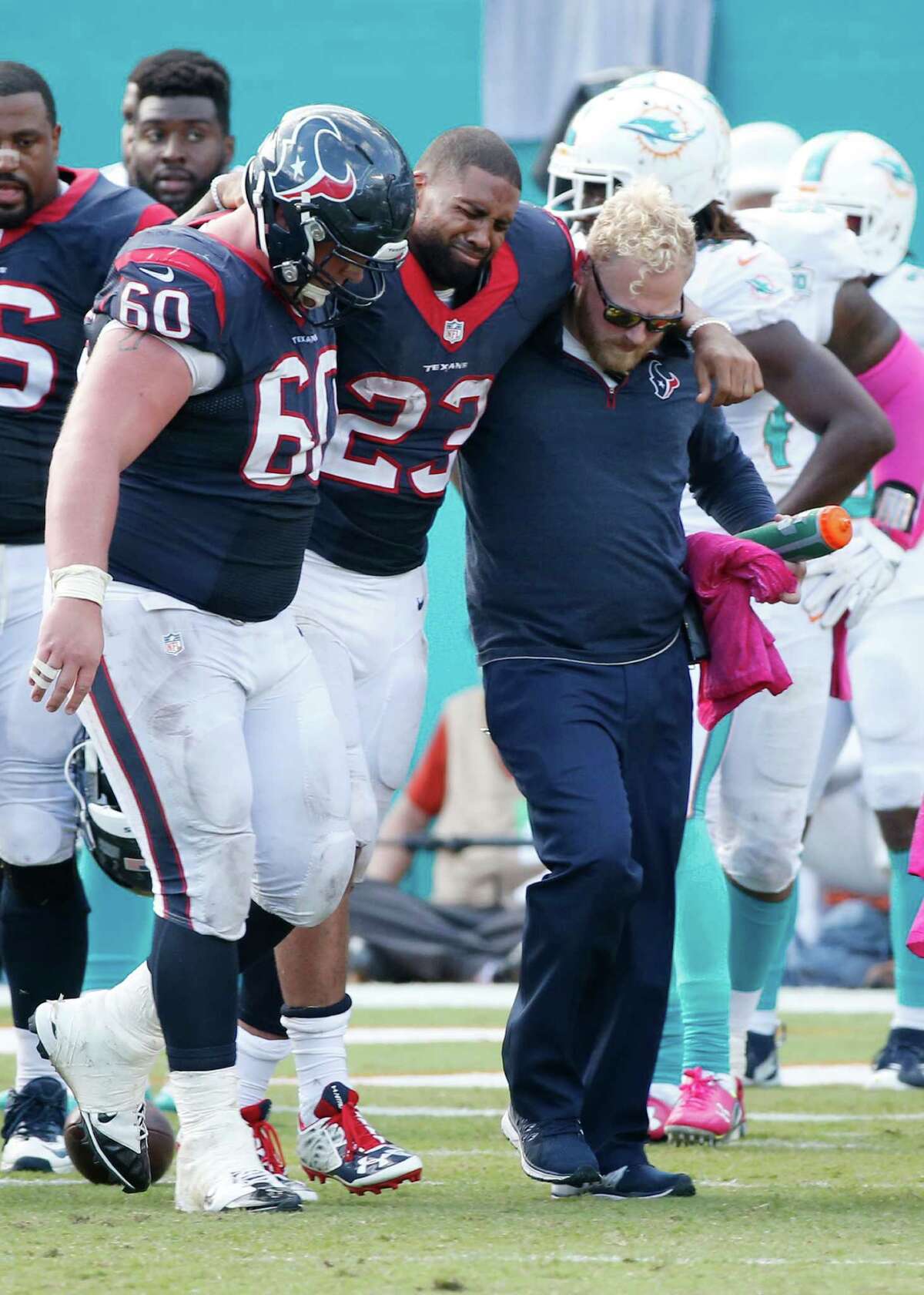 Houston Texans running back Arian Foster is helped off the field by center Ben Jones and an unidentified team training member during the second half of against the Miami Dolphins.