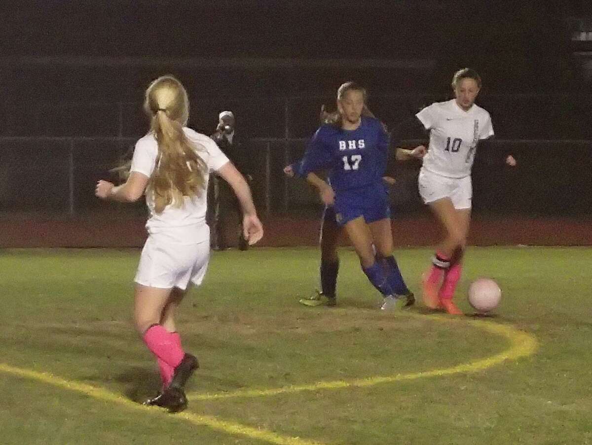 New Milford's Monica Baxter (10) dribbles the ball just outside the box as Brookfield's Shaye McGee defends and New Milford's Sarah Marsan (left) moves into position during their soccer game at New Milford High School Oct. 26, 2015.