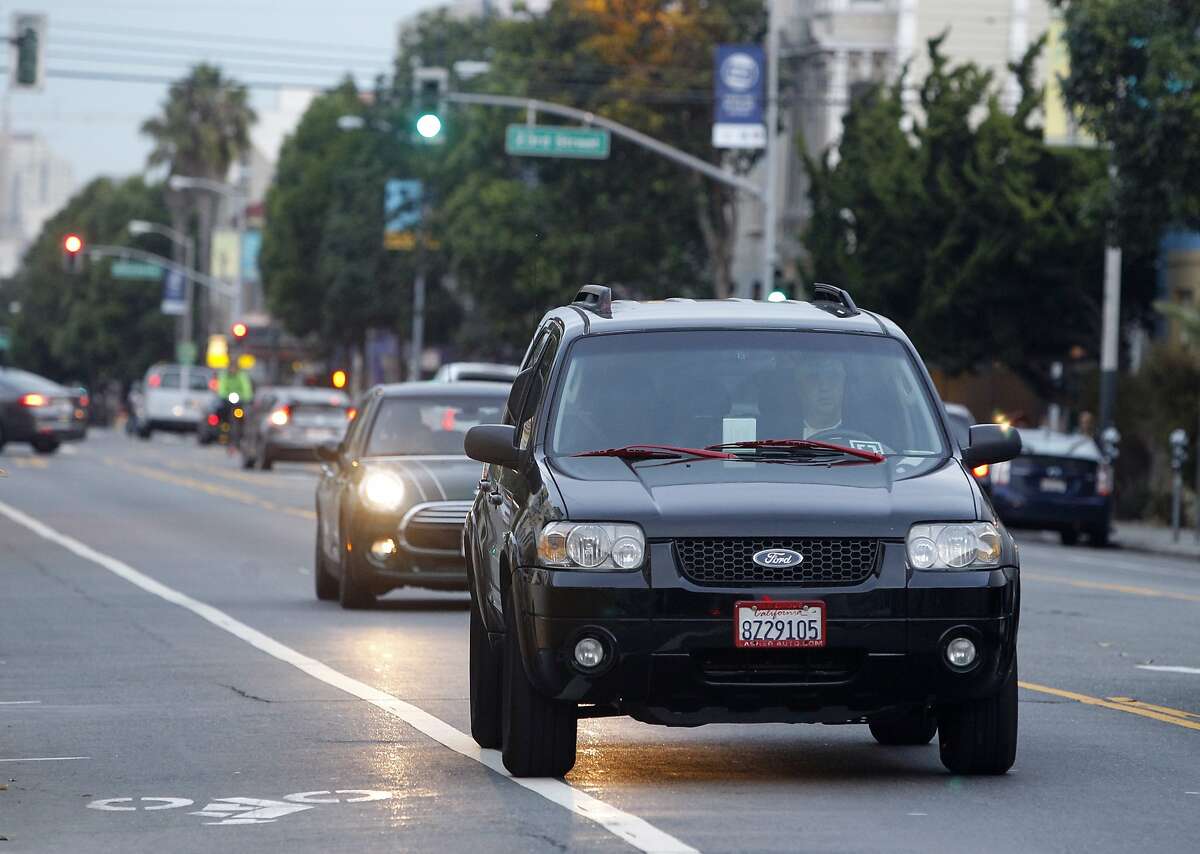 John Sollars drives his SUV on Valencia Street waiting to pick up passengers requesting the UberX ride service in San Francisco, Calif. on Tuesday, Oct. 27, 2015. Sollars generally avoids areas designated by Uber for surge pricing and concentrates more on his own strategy.
