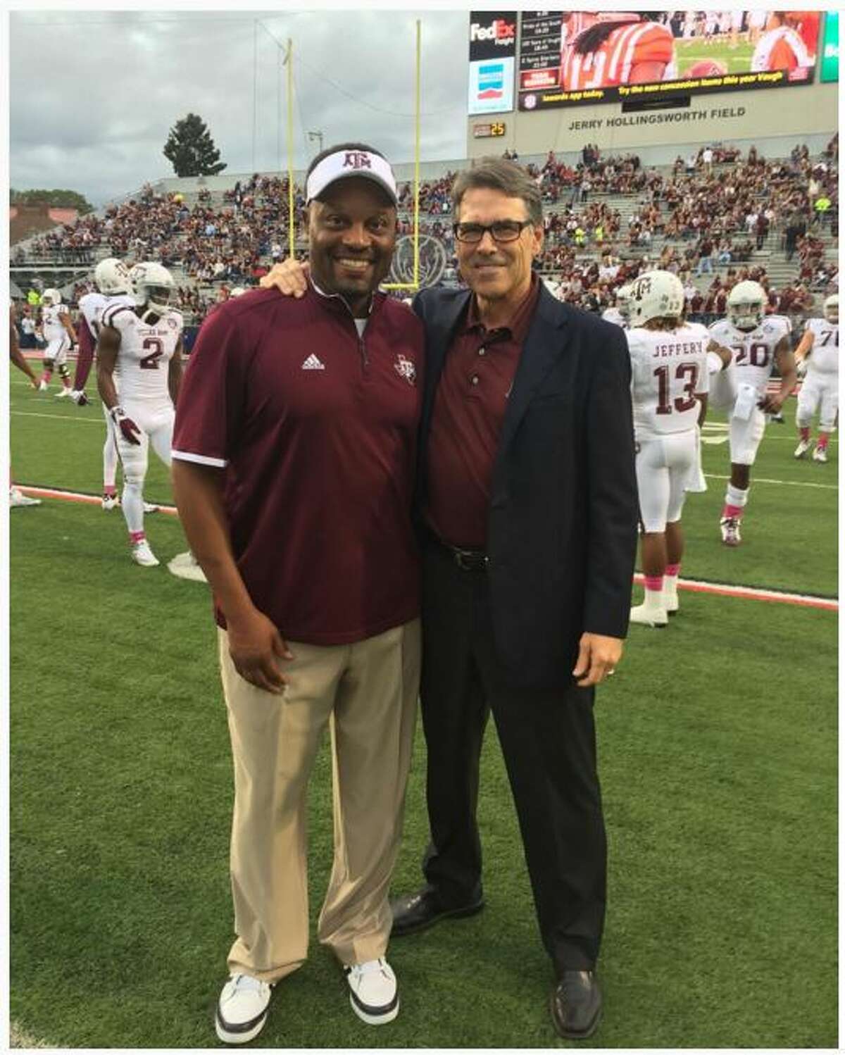 Rick Perry posing with Texas A&M University football coach Kevin Sumlin.