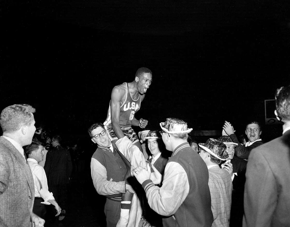 Jubilant USF students carry Russell off the court after the Dons beat LaSalle at Kansas City’s Municipal Auditorium on March 19, 1955, to win their 26th consecutive game and the NCAA basketball championship.