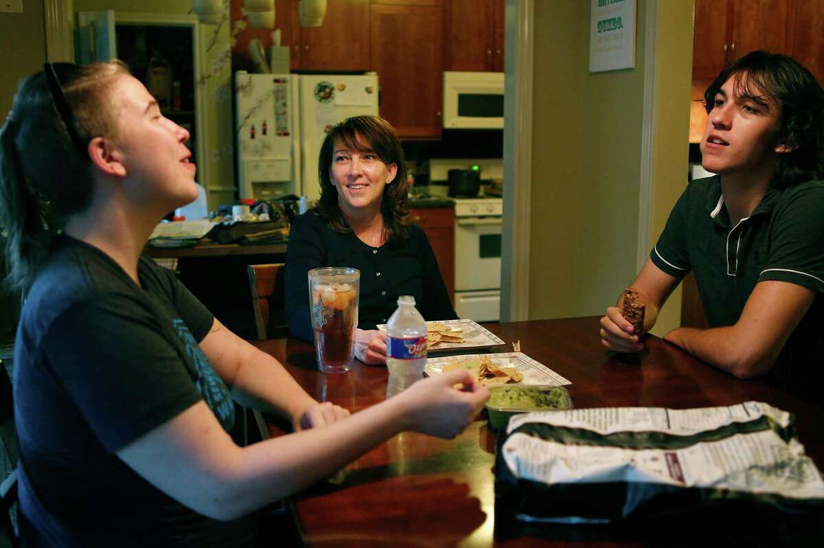 Brenda Hebert (center) talks with her children Alex (left) and Wolfgang (right) as they share a snack, Tuesday evening, Oct. 27, 2015, in Sugarland. Hebert was surprised to discover today that her PPO health plan would no longer be available for 2016.