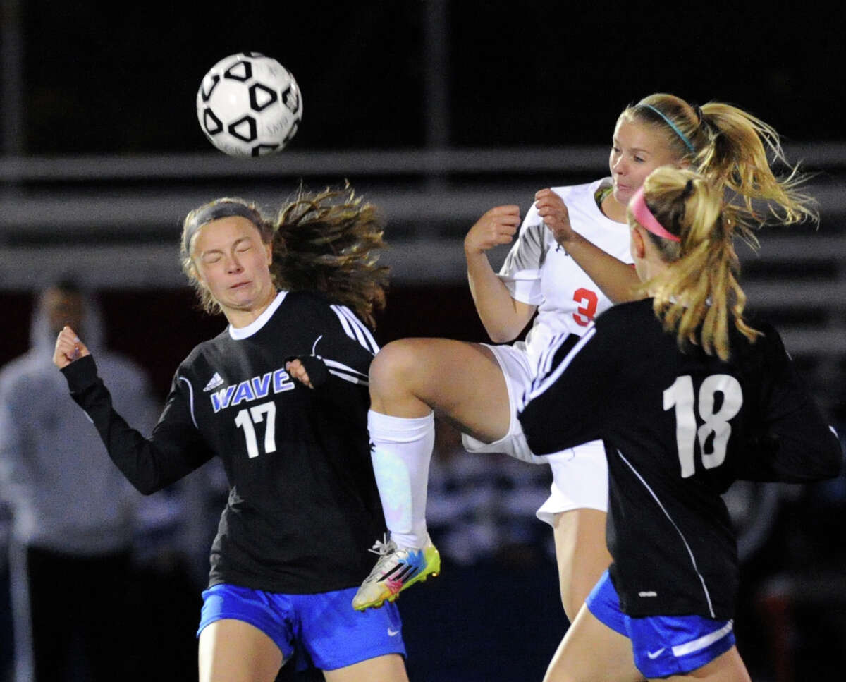 Darien’s Margaret Skeats (#17) battles for the ball with Greenwich’s Treloara Harrisson and Katherine Cronin during the Blue Wave’s 1-0 victory on Friday in Greenwich.